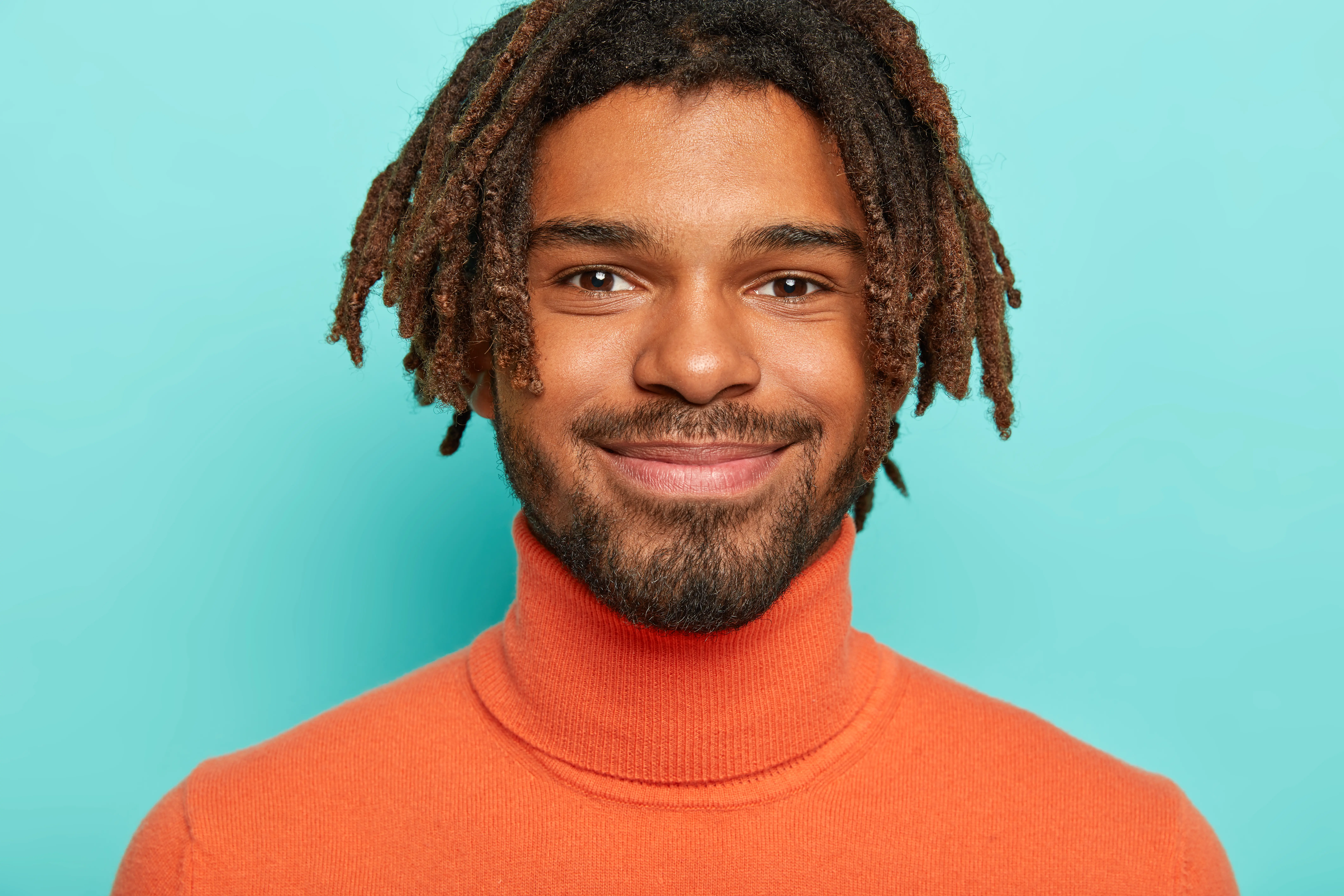 A man wearing an orange shirt and a necktie.