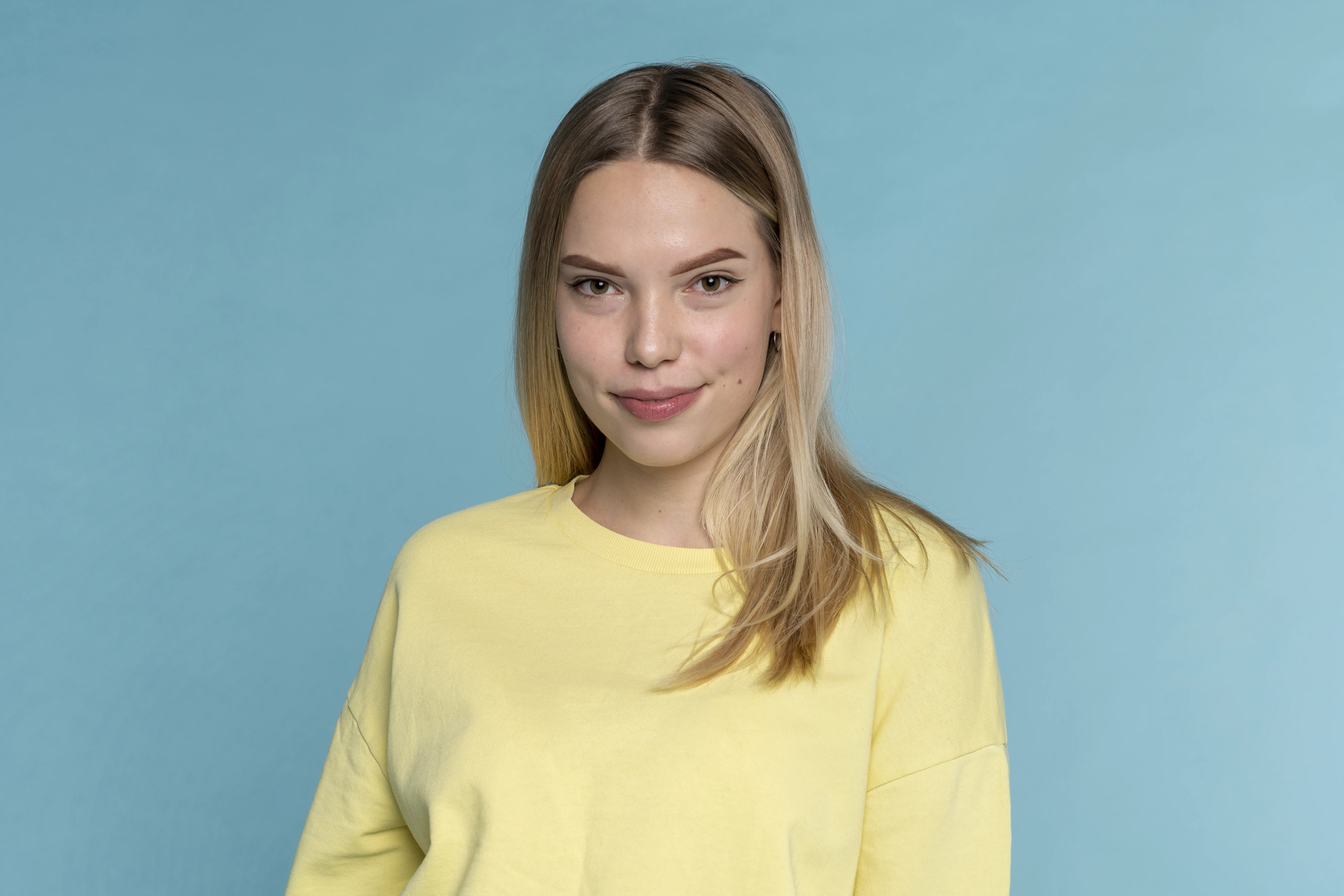 A woman wearing a yellow shirt and smiling.