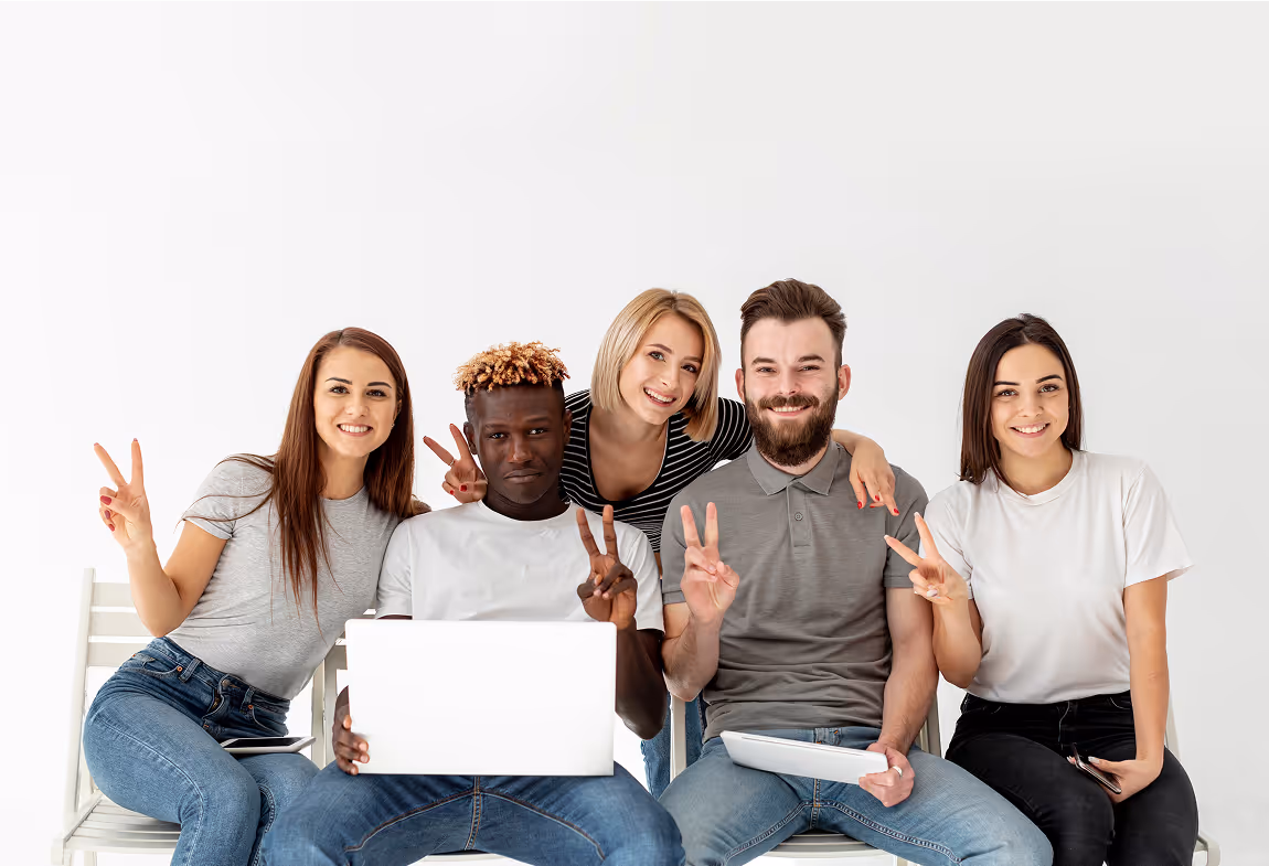 A group of people sitting on top of a white bench.