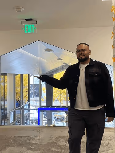 Man standing and pointing towards the Exit.