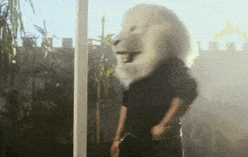 Man wearing lion mask giving a thumbs up