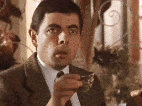 Shocked Mr. Bean dropping a cup.