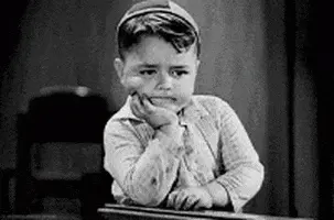 gif of a young boy waiting with his hand on his chin. 