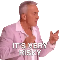 A man in a pink jacket and white shirt gestures with his hands, with white text overlayed that reads 'IT'S VERY RISKY'.