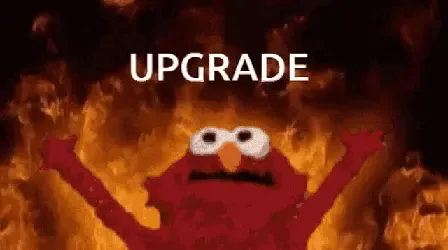 Elmo with his arms up in front of a fire with the word Upgrade.
