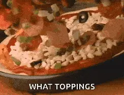 Close up of pizza toppings being added.