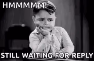 A black and white image of a young child resting their chin on their hand with text that says 'HMMMMM! STILL WAITING FOR REPLY'
