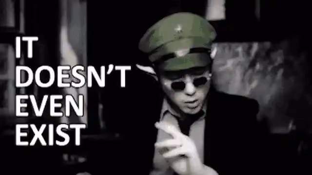 A person with pointed ears, wearing a green cap and sunglasses, says "It doesn't even exist" in a black-and-white gif.