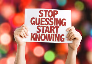 Stop Guessing Start Knowing placard with bokeh background