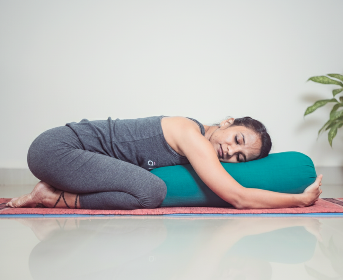 Woman practicing a seated side stretch while following an online yoga class on a tablet.