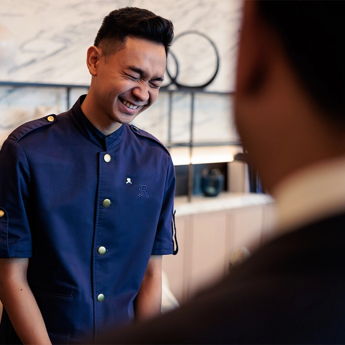 Marriott employee smiling whilst interacting with customer.