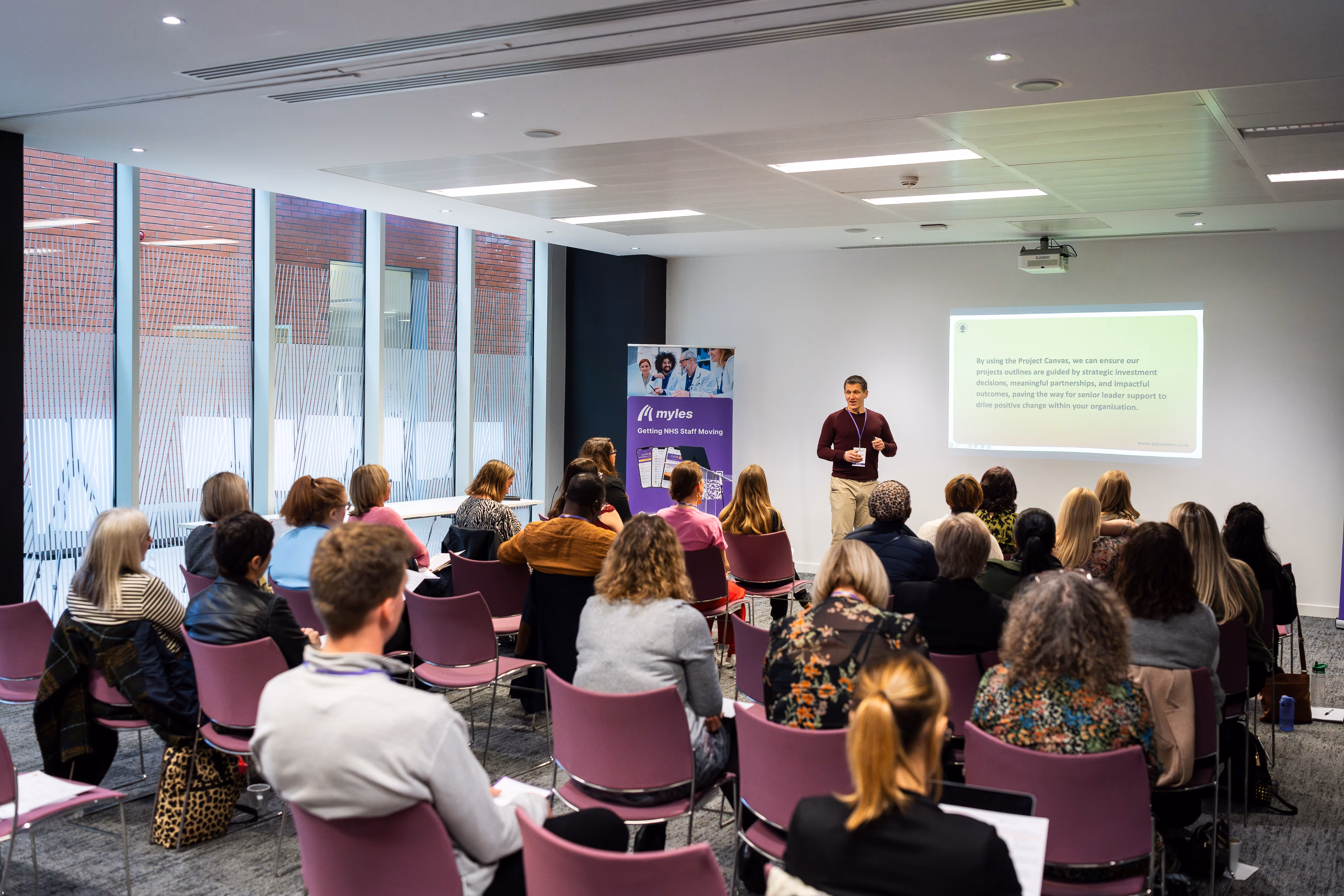A photo of Gary presenting to a large group of colleagues.