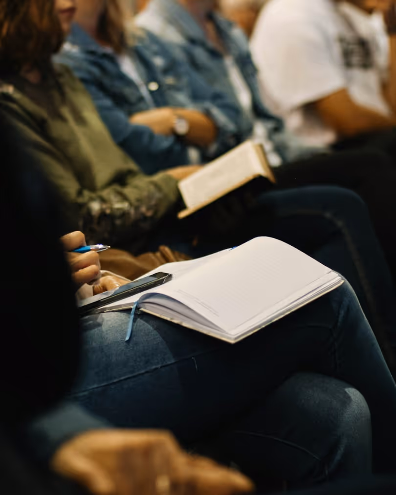 A photo of attendees taking notes during a leadership development session.