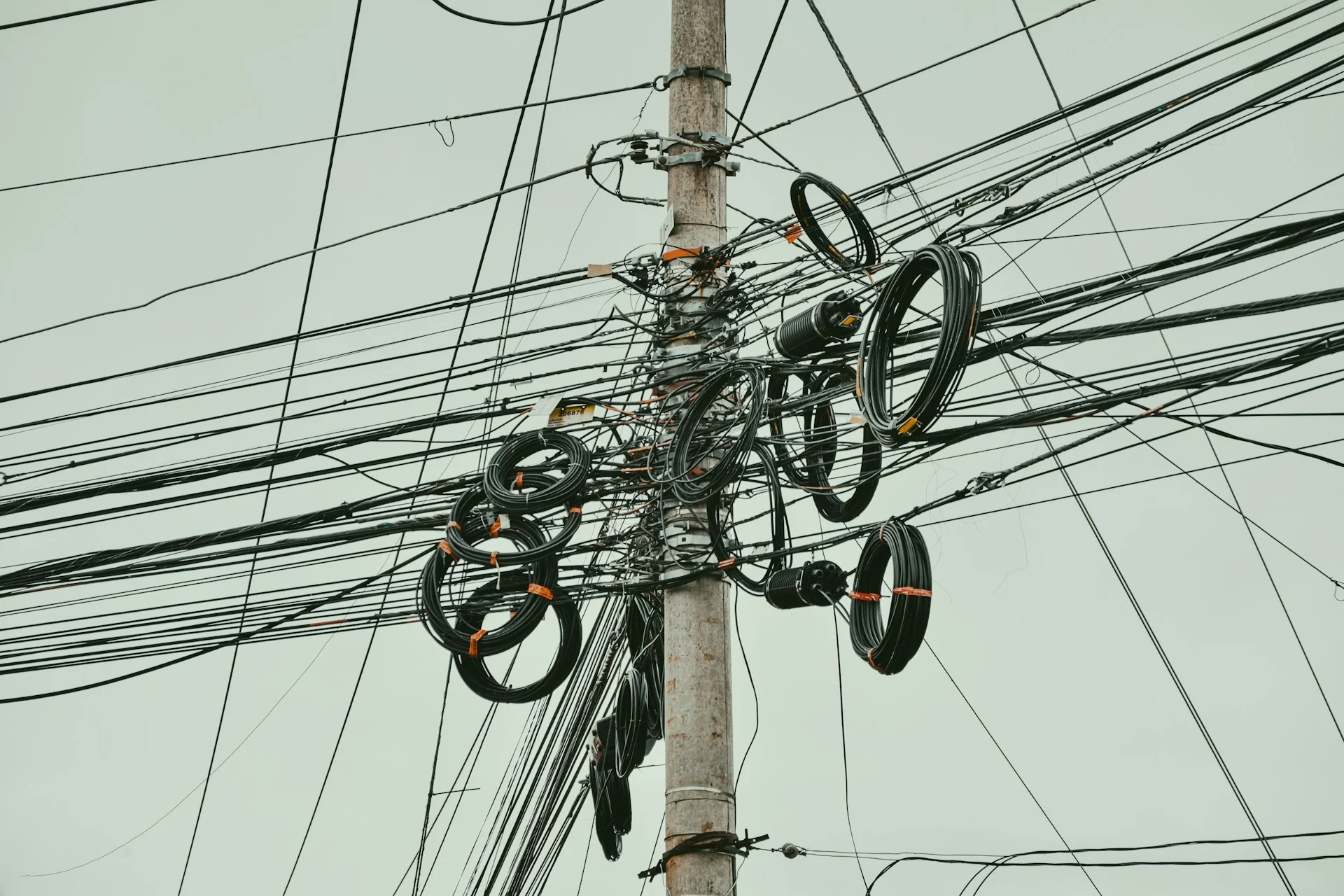A photograph of a telephone mast with reams of cables running to/from it. This signifies the connection that technology can provide. 