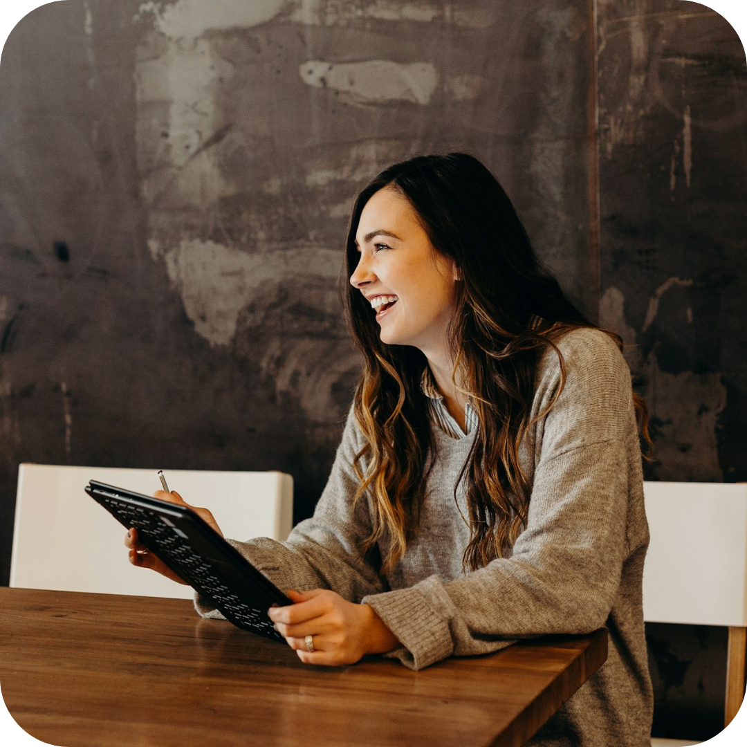 An employee laughing, looking at someone out of frame.