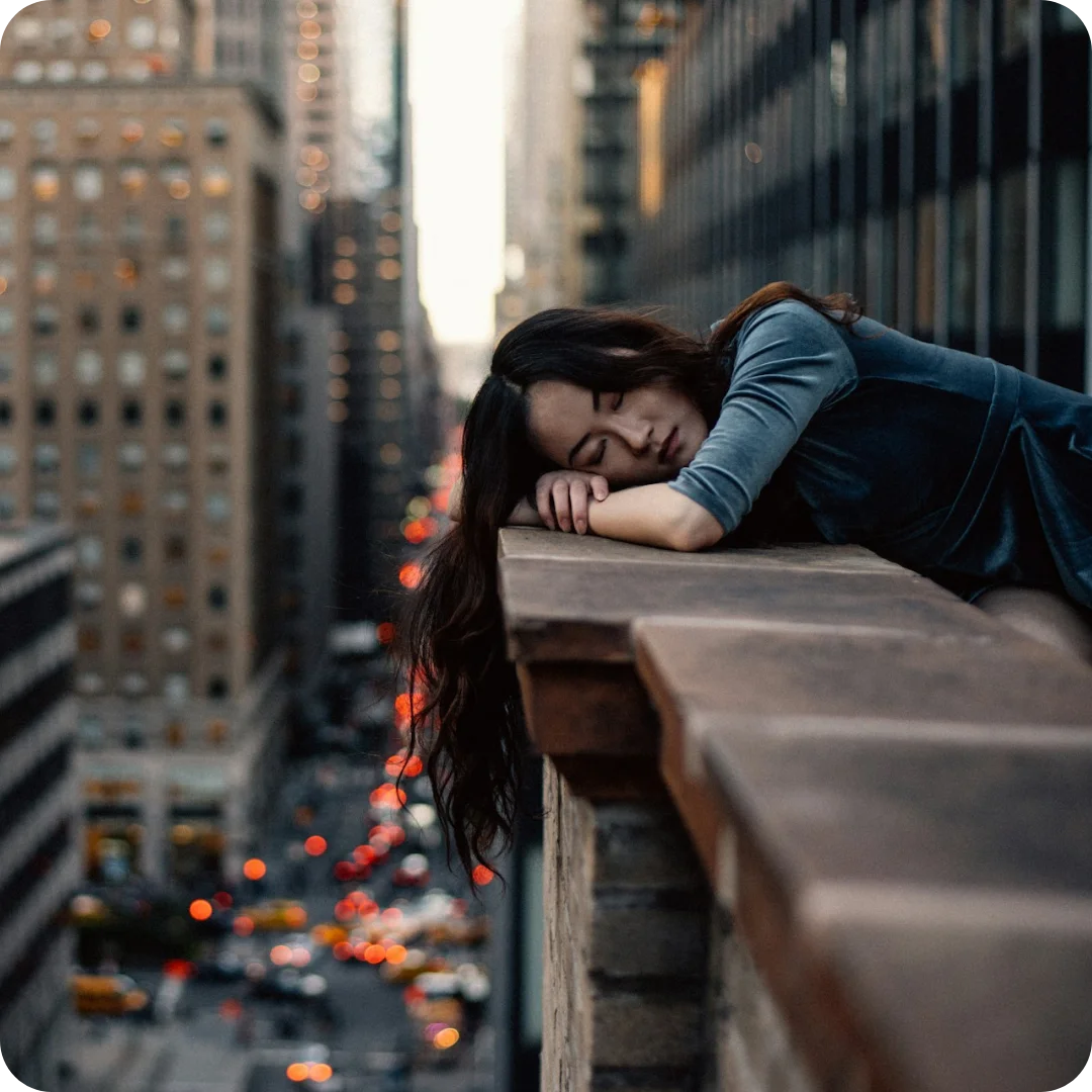 A photo of a tired employee leaning on a wall getting some rest.