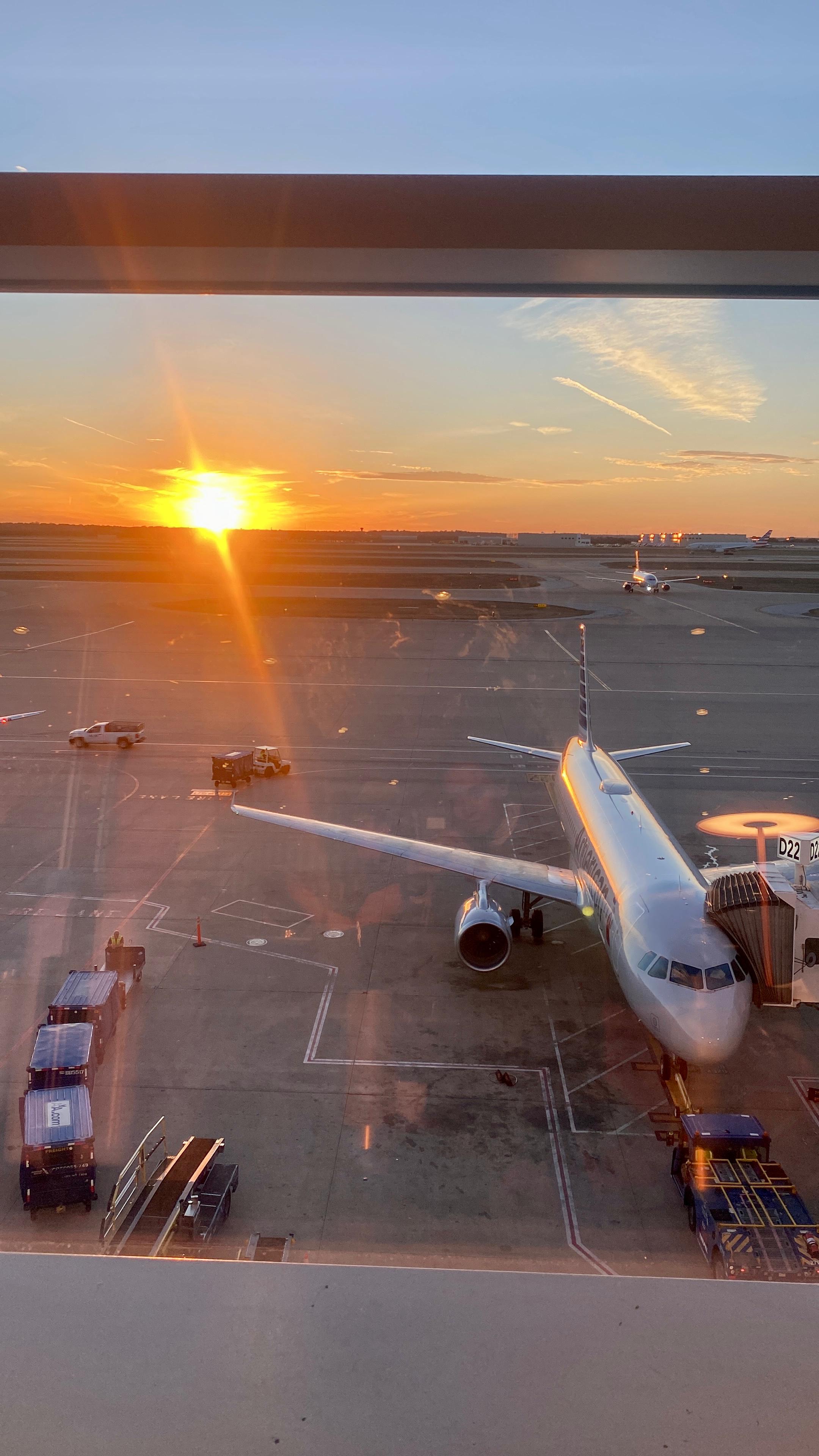 A plane at the airport during sunset.