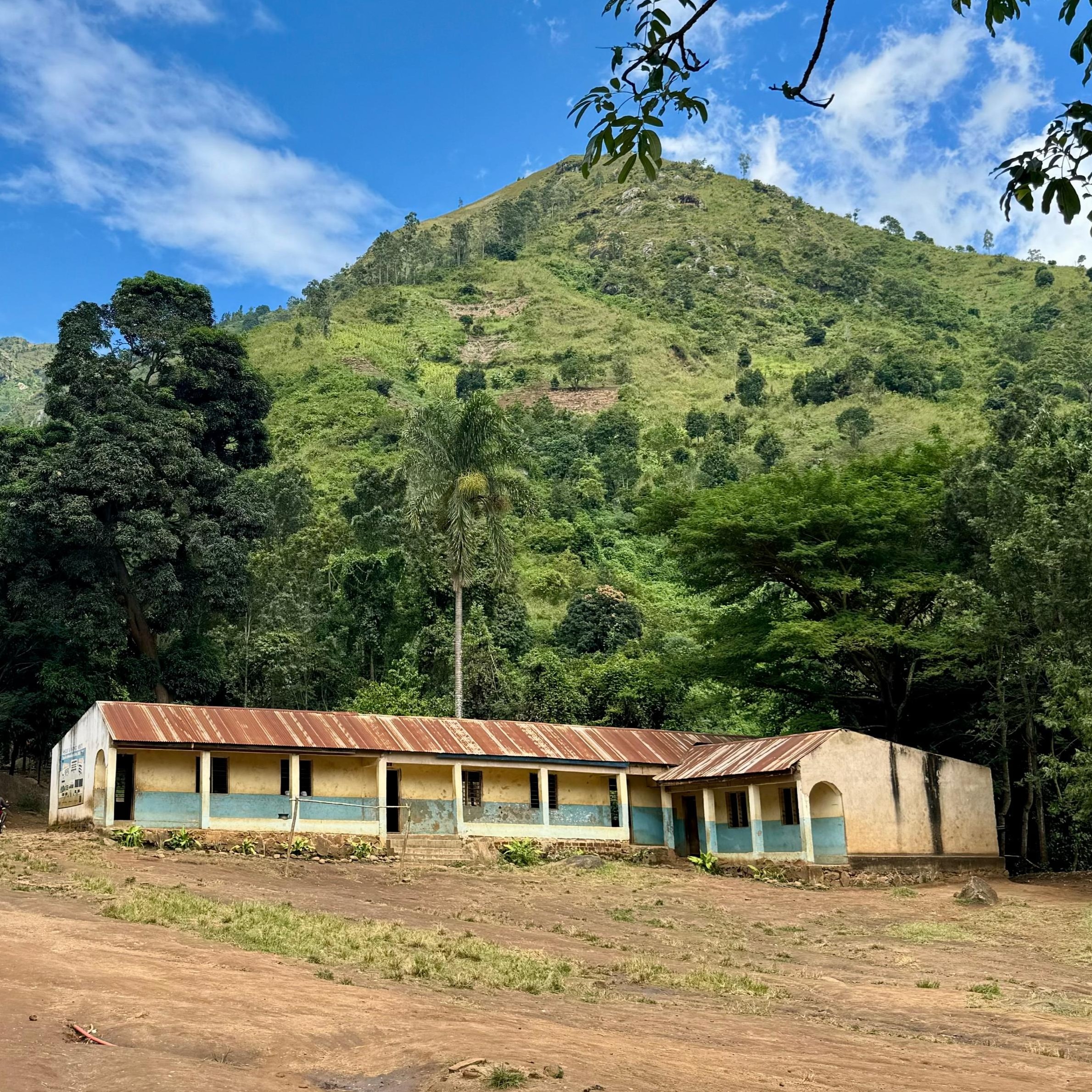 A school in Tanzania under a green hill.