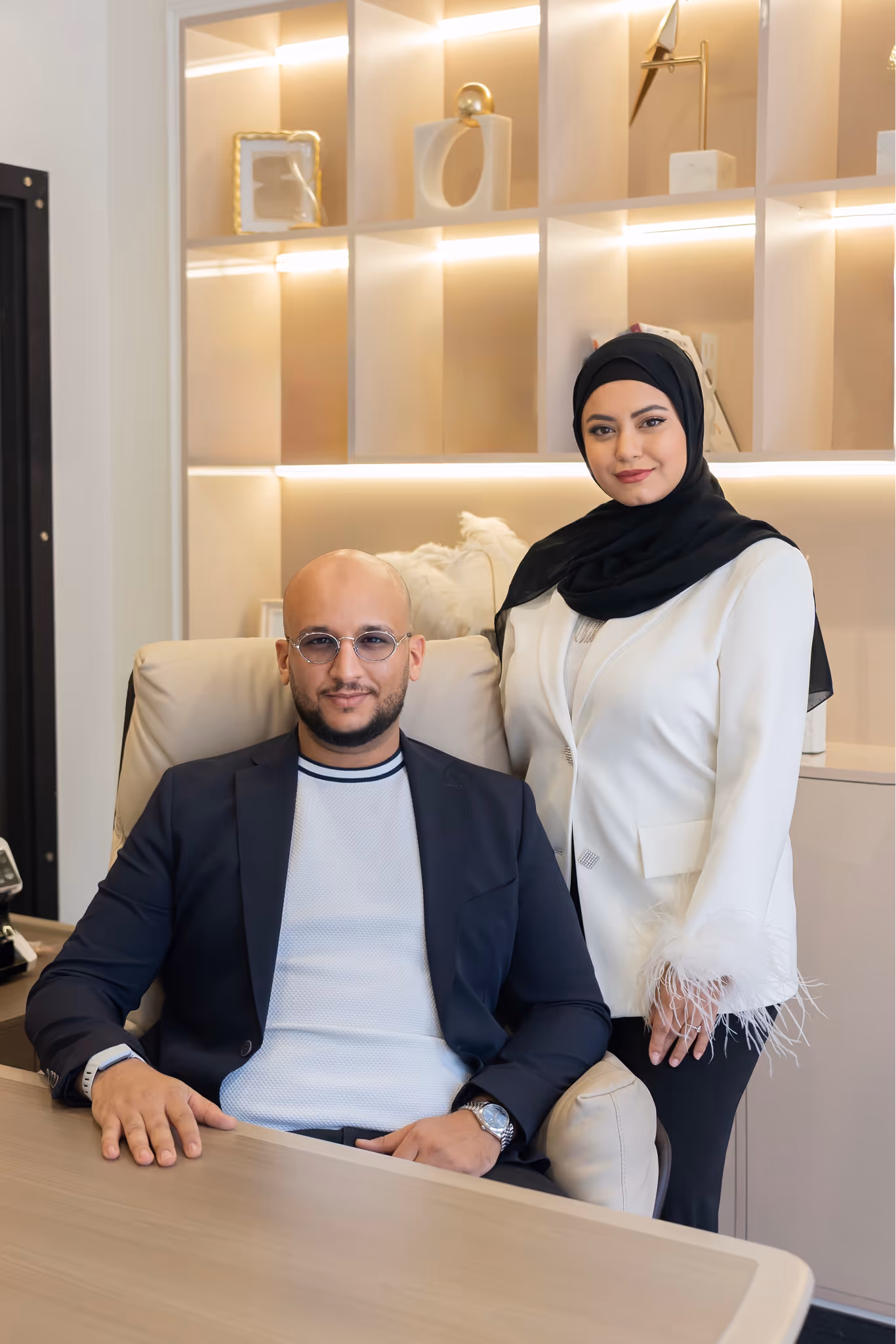 Two people posing professionally in an office environment.