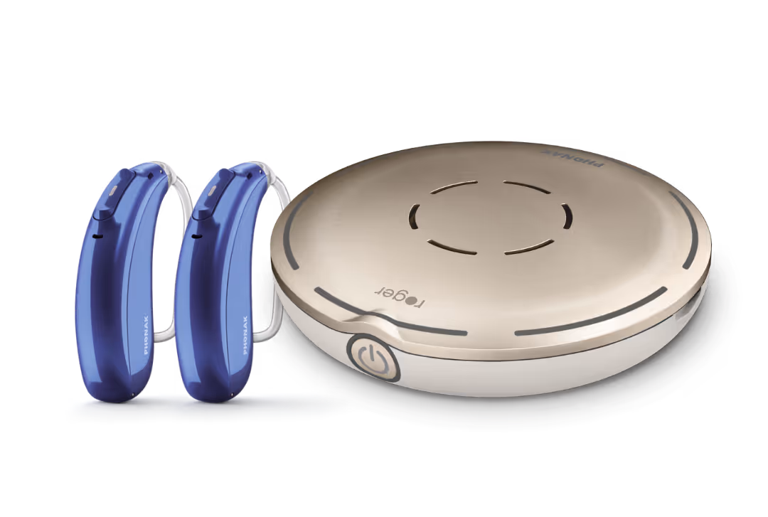 Two blue hearing aids next to a beige wireless microphone device on a white background.