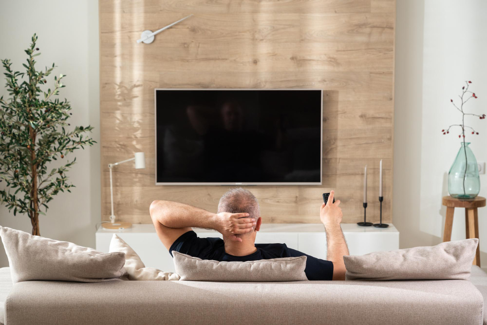 man sitting on sofa in front of TV