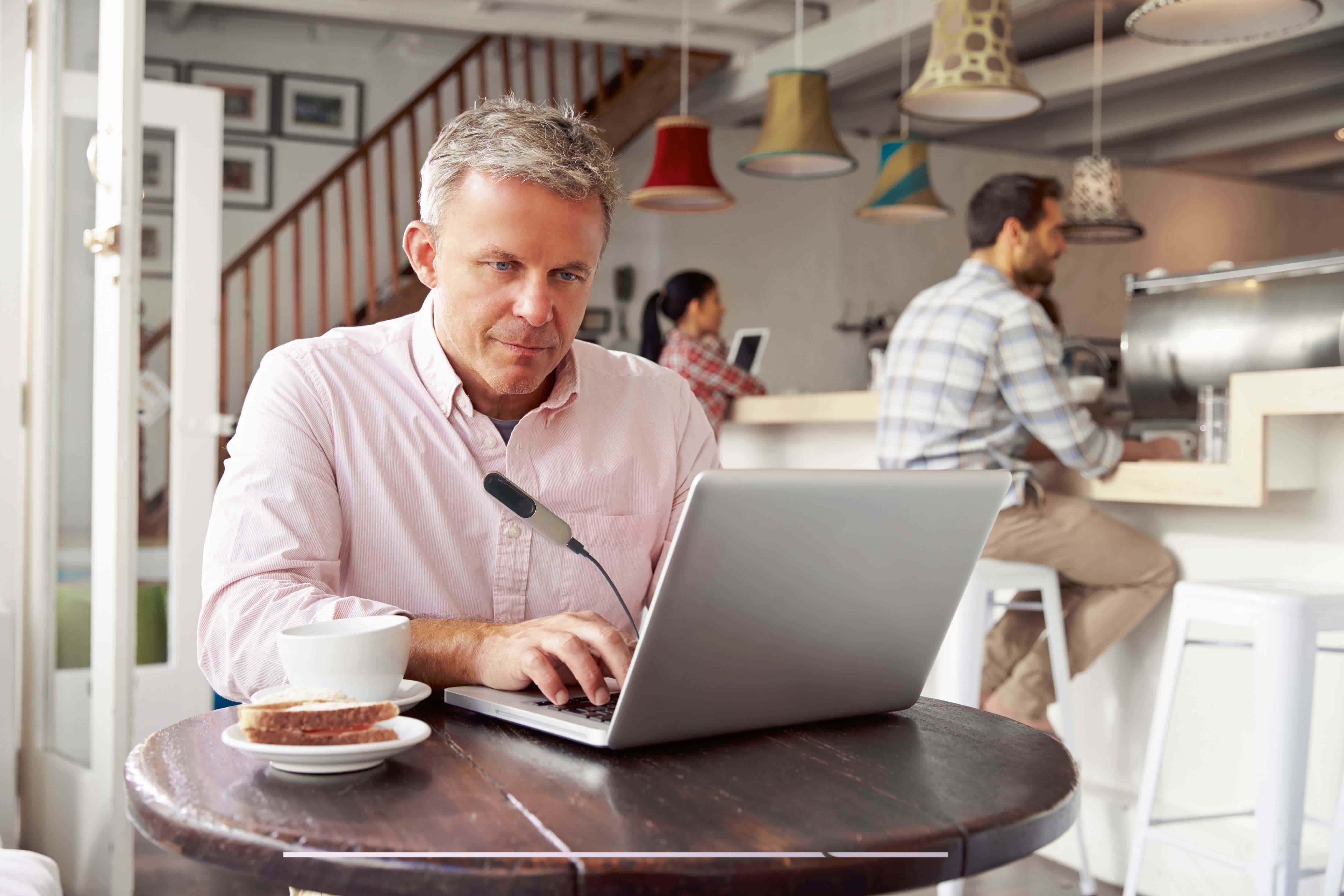Man working on laptop at cafe