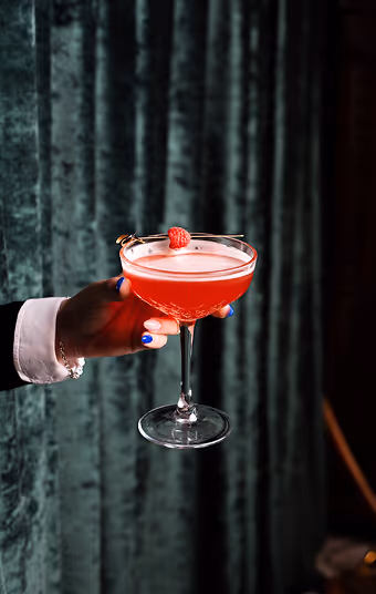 An image of a hand holding a red drink