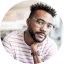 Young professional man in Dallas smiling during a career coaching and mentoring session. Preem Coaching & Mentoring Services in Dallas TX