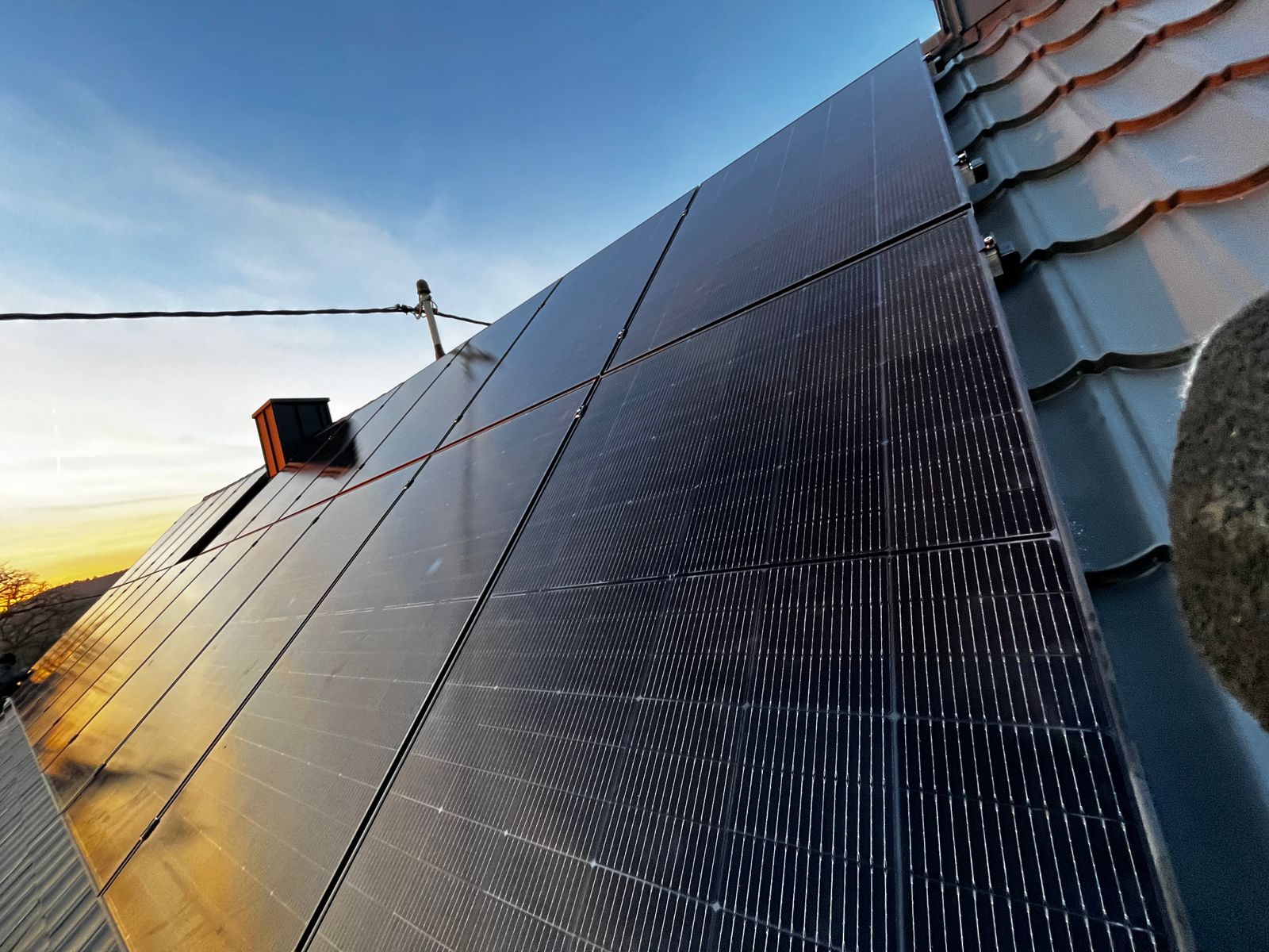 Photovoltaikanlage mit 42 montierten 440-Watt-Solarmodulen auf Blechziegel-Dach, Montage mit speziellen Stoppschrauben, Südausrichtung für hohe Eigenverbrauchsquote und schnelle Amortisation.