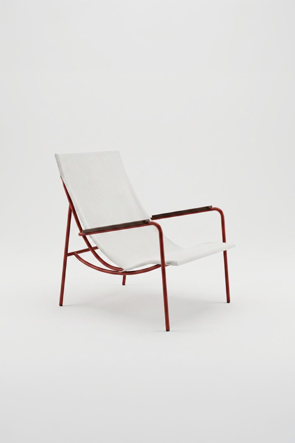 Tropico chair on a plain light background, with a red tube frame, cream canvas seat and wooden armrests, seen at three-quarters.