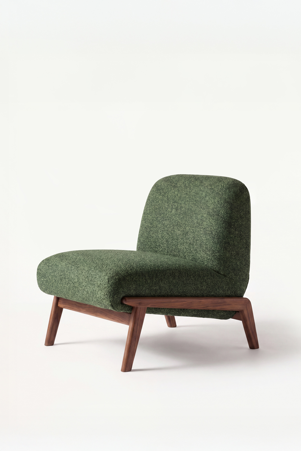 Three-quarter view of the green Camilla chair, with the fabric's flecked texture and the walnut frame wrapping the seat.