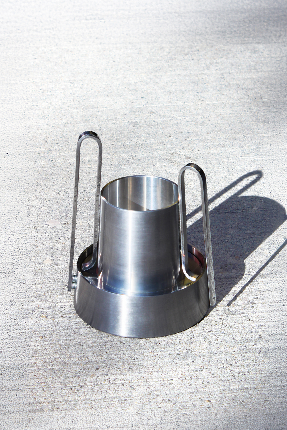 Bloom coffee machine in brushed metal on concrete, with two tall loop handles