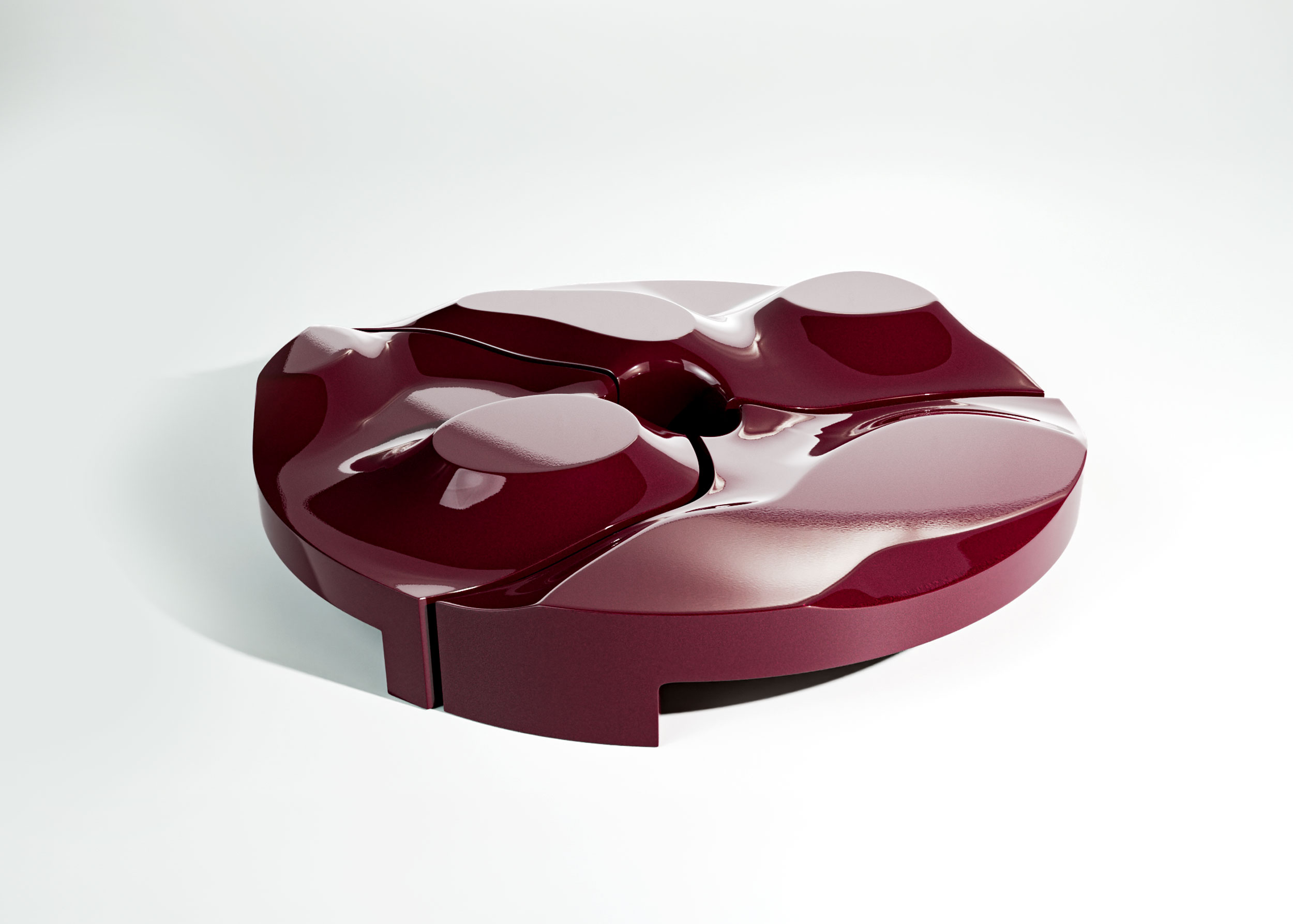 Rendering of the glossy burgundy Sun Disc table from above, a low round table split into three wavy segments with raised oval platforms and a dark hole at the centre.