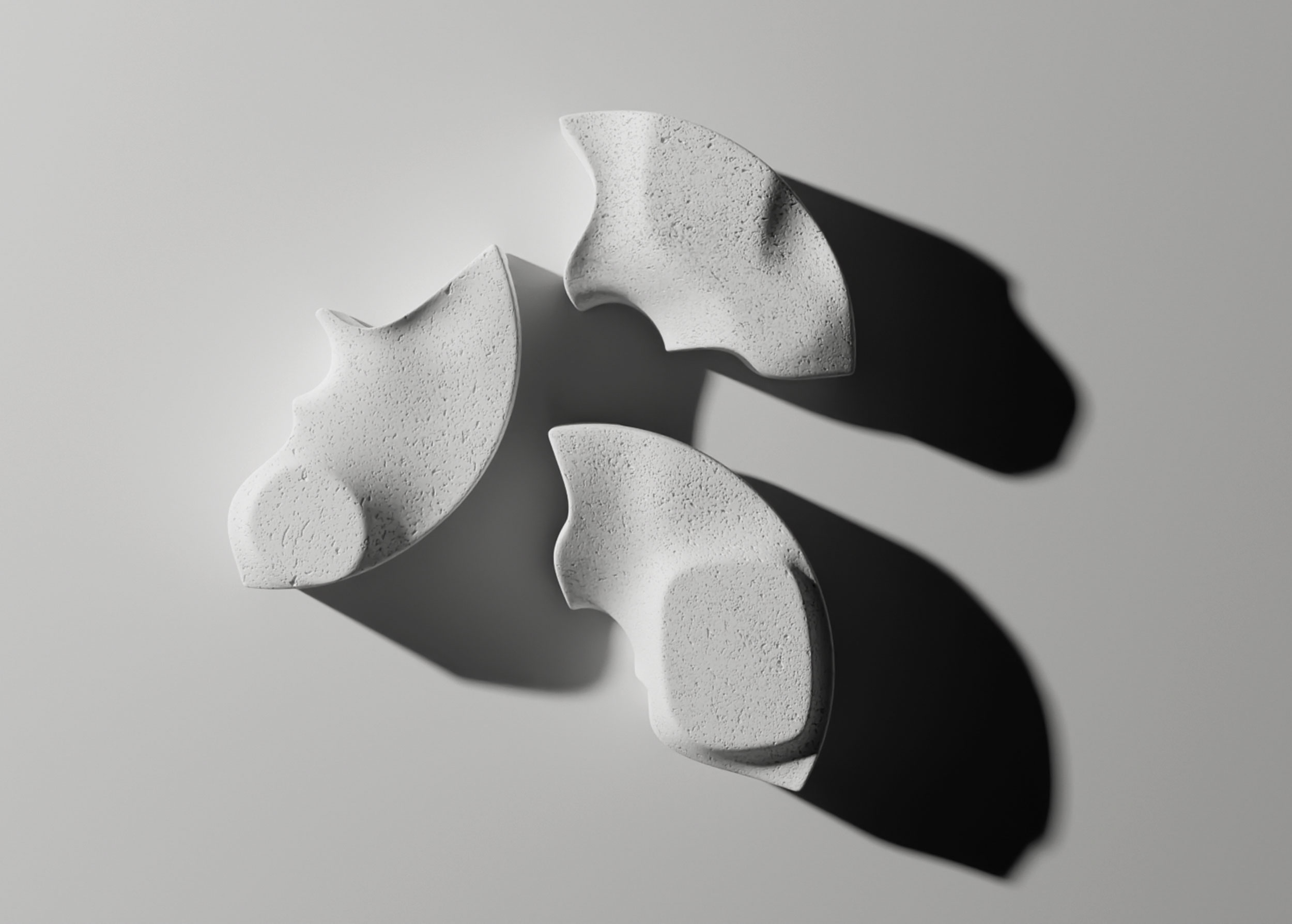Rendering of the Sun Disc table as three separate pale, speckled fan-shaped pieces seen from above, each with a raised, rounded platform and a long shadow.