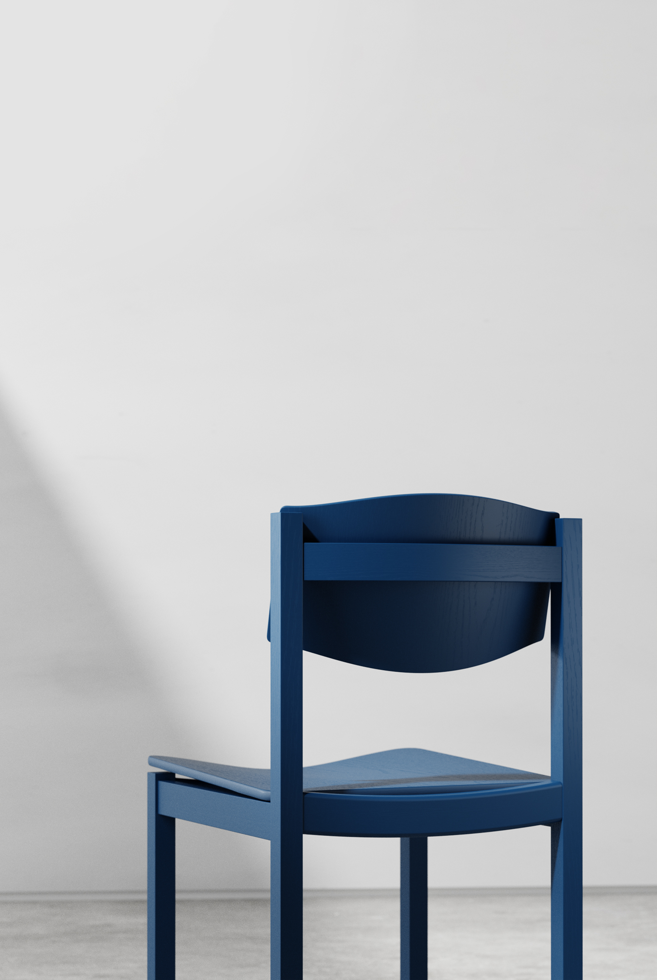 Rear view of the blue chair, showing the back of the curved panel behind a cross rail and the underside of the seat.