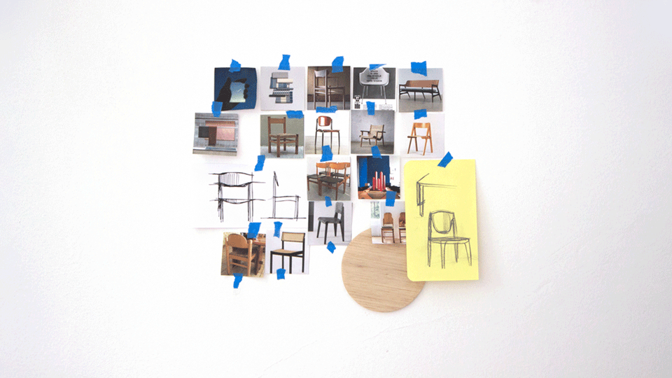 Side detail of the blue chair, with the curved backrest panel, the dished seat and the square frame, in soft daylight.