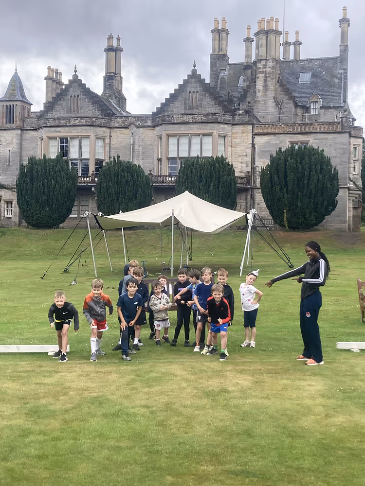 kids ready to start running on grass with castle in background