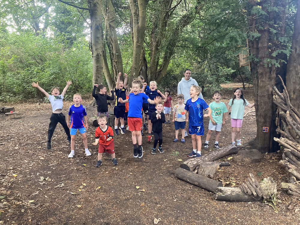 group of 15 kids jumping in the forest