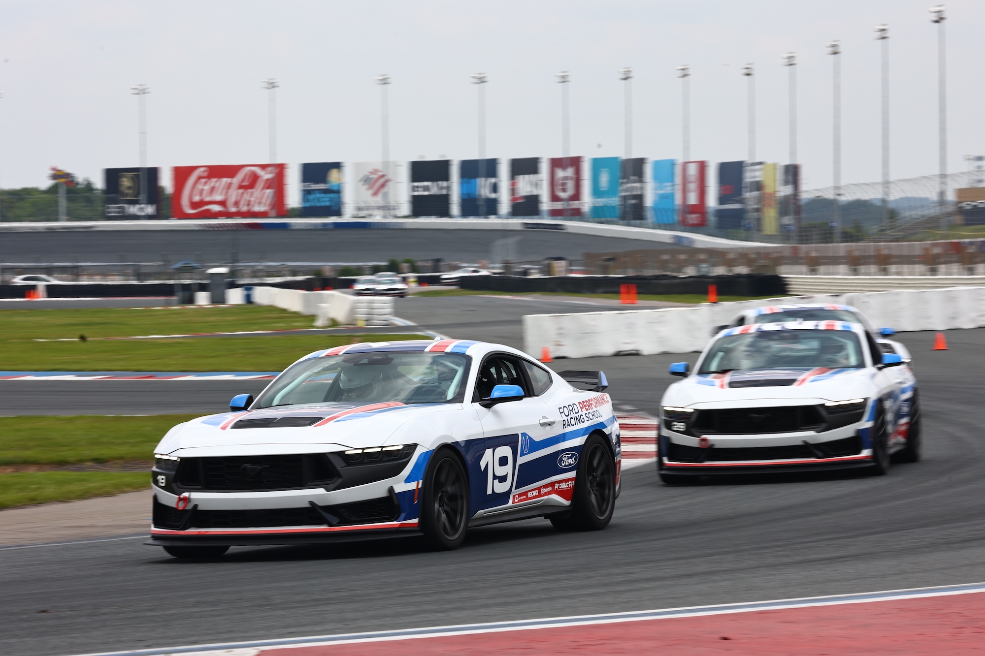 Close-up of a blue McLaren 750S sports car showing the side mirror, window, and front wheel with tire details.