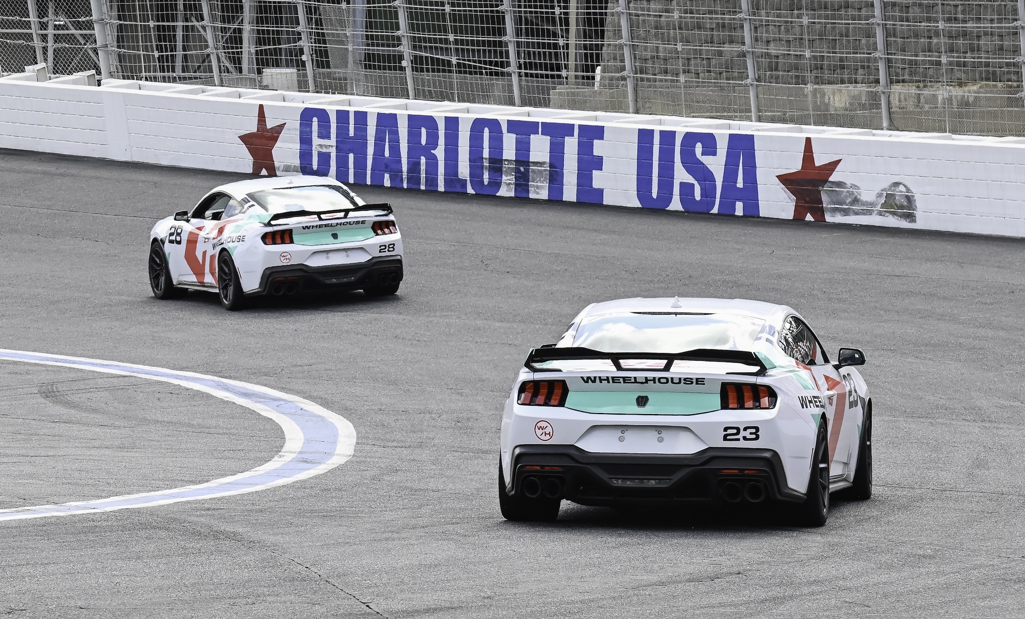 Close-up of a blue McLaren 750S sports car showing the side mirror, window, and front wheel with tire details.