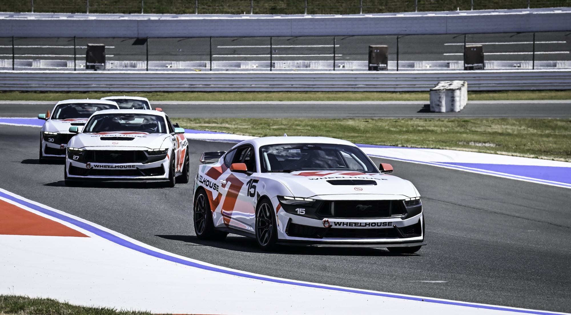 Close-up of a blue McLaren 750S sports car showing the side mirror, window, and front wheel with tire details.
