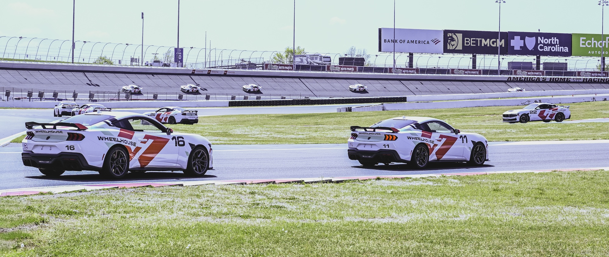 Close-up of a blue McLaren 750S sports car showing the side mirror, window, and front wheel with tire details.