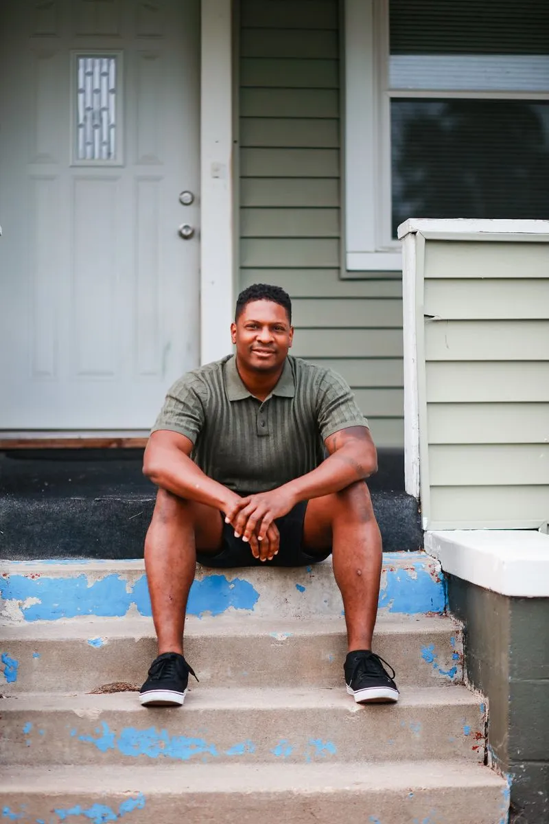 A man sitting on the steps of a house.