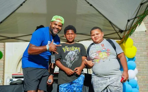 A man and two boys standing under a tent.