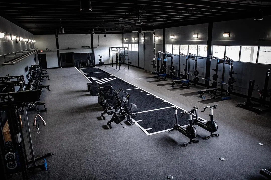 A gym with a row of exercise equipment.