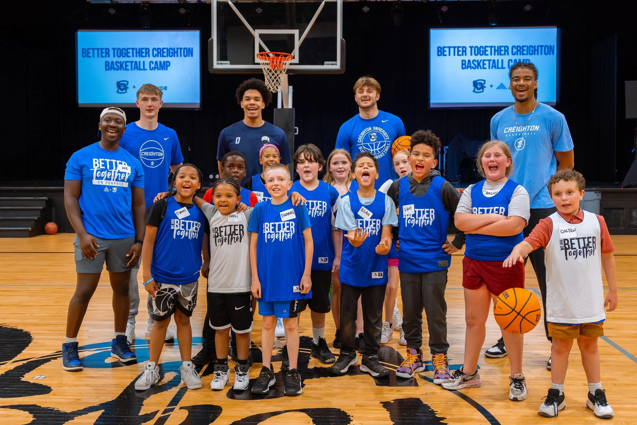 A group of young boys and girls standing on a basketball court.