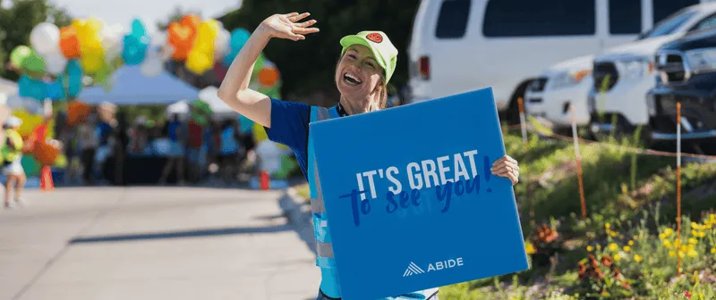 A woman holding a sign that says it's great to be happy.