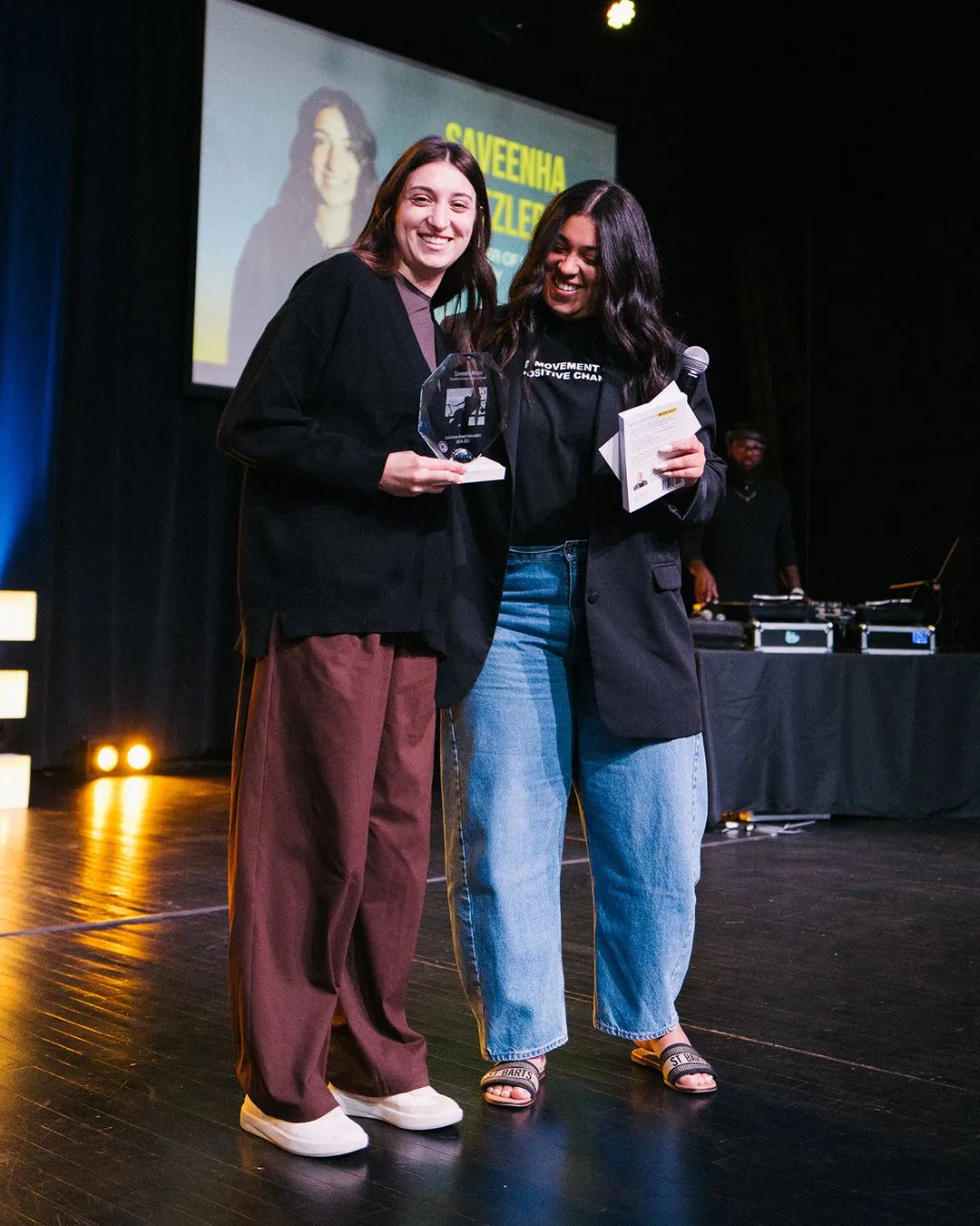 Two women standing next to each other on a stage.