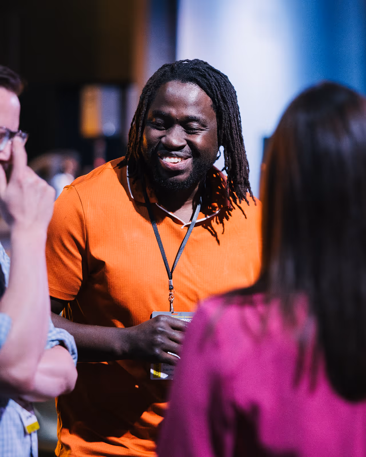 A man with dreadlocks talking on a cell phone.