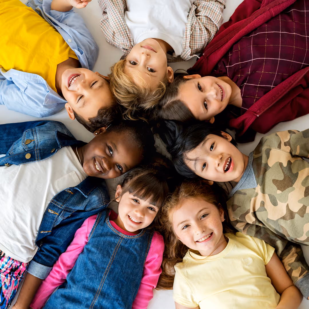 Happy group of kids laying on ground.. Therapy academy in Frisco Texas